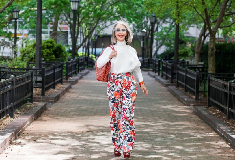 Image of Honey Good walking in floral pants and a white blouse